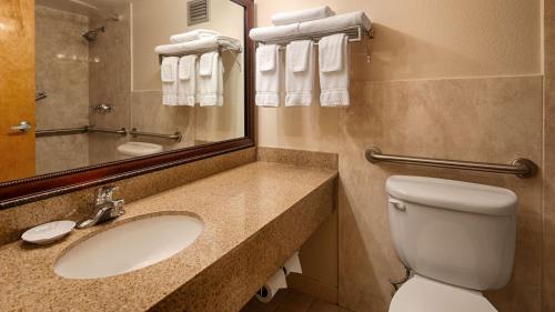 a bathroom with a sink and a toilet and a mirror at Baymont Inn & Suites in Marietta
