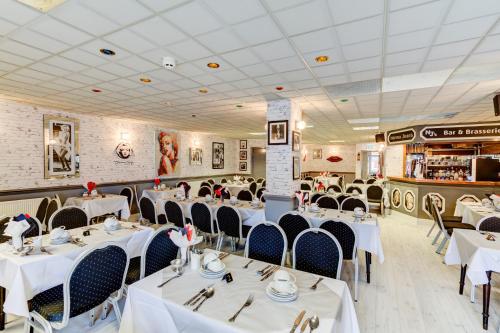 a dining room with white tables and chairs at The Sandringham Court Hotel & Apartment Welcoming Large and Small Groups for 16 years in Blackpool