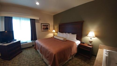 a hotel room with a bed and a television at Best Western Salbasgeon Inn & Suites in Reedsport