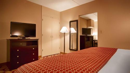 a hotel room with a bed and a flat screen tv at Best Western Park Hotel in Warren