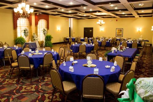 a ballroom with blue tables and chairs and a room filled with at Best Western Park Hotel in Warren
