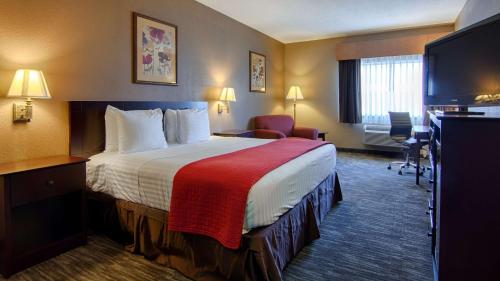 Habitación de hotel con cama grande y escritorio. en Best Western Dayton Inn & Suites, en Dayton