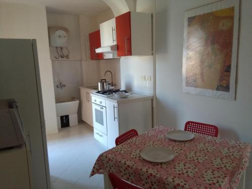 a kitchen with a table and chairs and a kitchen with a table and a table at The House on the Beach in Giardini Naxos