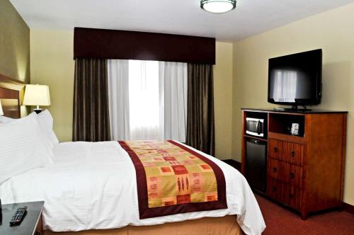 a hotel room with a bed and a flat screen tv at Best Western Plus Layton Park Hotel in Layton