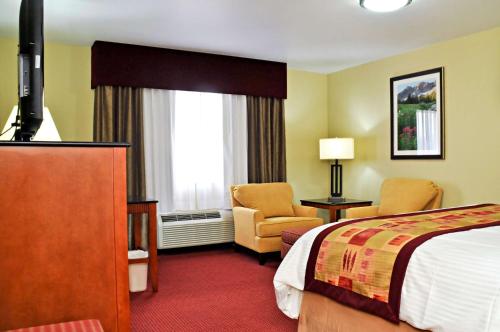 a hotel room with a bed and a chair at Best Western Plus Layton Park Hotel in Layton