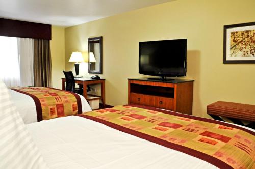 a hotel room with two beds and a flat screen tv at Best Western Plus Layton Park Hotel in Layton