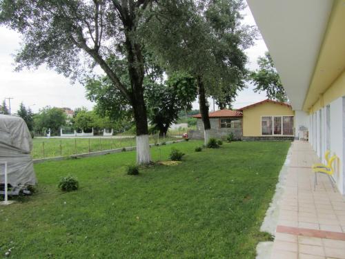 a yard with two trees and a house at Sun Studios Pieria in Paralía Skotínis