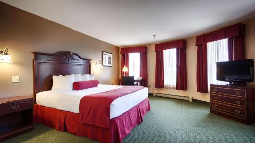 a hotel room with a bed and a flat screen tv at BEST WESTERN The Hotel Chequamegon in Ashland