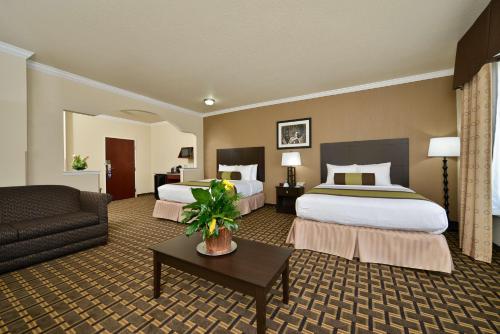 um quarto de hotel com duas camas e um sofá em Best Western Plus Cutting Horse Inn & Suites em Weatherford