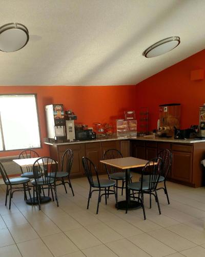 a restaurant with tables and chairs in a kitchen at Howard Johnson by Wyndham Wilmington in Wilmington