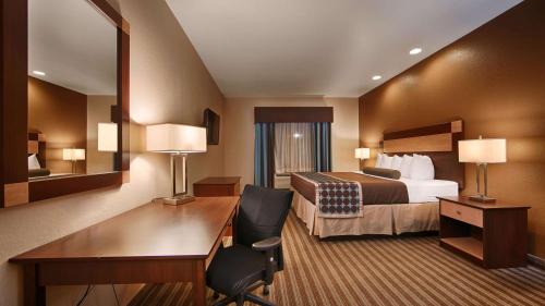 Best Western Plus Palo Alto Inn and Suites في سان انطونيو: غرفة في الفندق بها سرير ومكتب ومكتب
