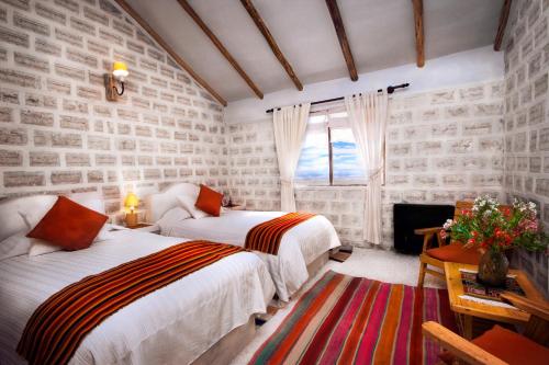 a bedroom with two beds and a window at Hotel de Sal Luna Salada in Colchani