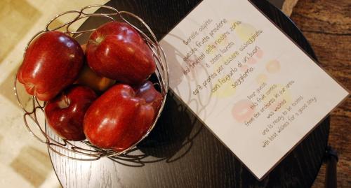 a bowl of tomatoes sitting next to a note at Hotel Carlton in Ferrara