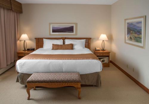 a hotel room with a large bed and two lamps at Jasper Inn & Suites by INNhotels in Jasper
