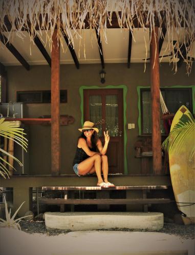 a woman sitting on the steps of a house at Cafe de la Suerte in Pavones