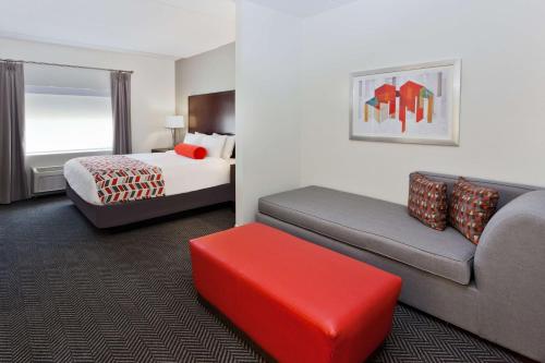 Habitación de hotel con cama y sofá en Best Western Plus Columbus North Fort Moore en Columbus