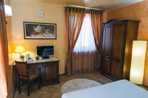 a bedroom with a desk with a computer and a window at Hotel Al Ritrovo in Piazza Armerina