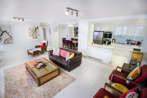 a living room with couches and a table and a kitchen at Albatross North Apartments in Gold Coast