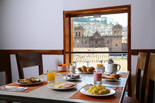 a table with breakfast food and a view of the city at Casa Andina Standard Cusco Plaza in Cusco