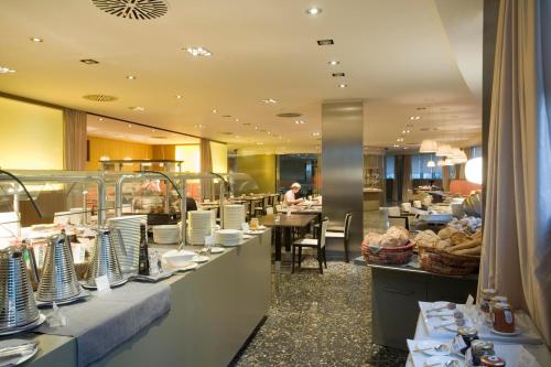 a restaurant with a buffet line with plates and food at UNA HOTELS T Hotel Cagliari in Cagliari