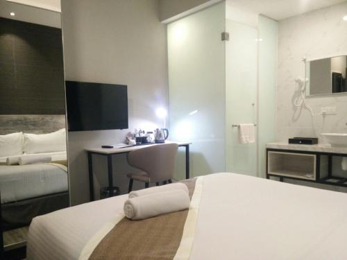 a hotel room with a bed and a desk at The Leverage Business hotel (Skudai) in Johor Bahru