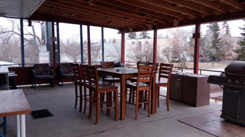 a patio with a table and chairs and a grill at Southview Motel in Westlock