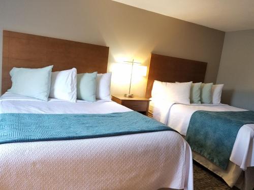 a hotel room with two beds with white sheets at Hampton Village Inn in Hampton