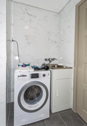 a washer and dryer in a room with a wall at Hamilton on Beaumont in Newcastle
