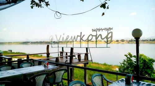 a restaurant with tables and chairs next to a lake at Fortune View Khong Hotel Nakhon Phanom in Nakhon Phanom
