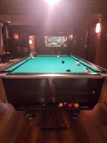 a pool table in a dark room with afits at Miracle Suite in Ipoh