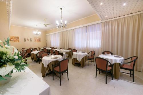 a dining room with tables and chairs with white tablecloths at Hotel Morchio Mhotelsgroup in Diano Marina