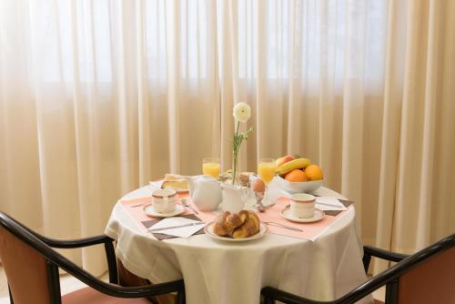 a table with a plate of food and fruit on it at Hotel Morchio Mhotelsgroup in Diano Marina