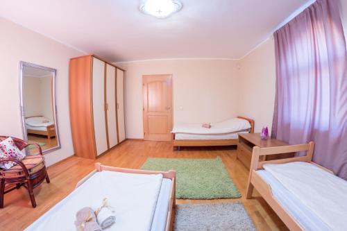 a living room with two beds and a table at Villa Ami in Novi Sad