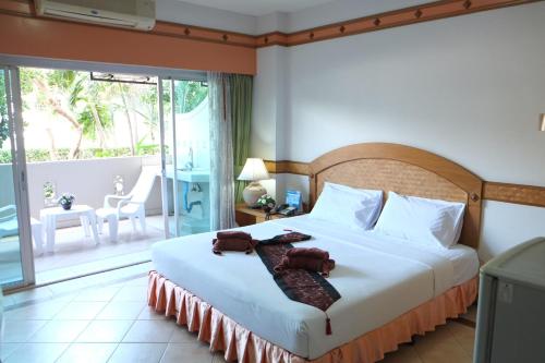 a bedroom with a bed and a balcony at Diana Garden Resort - SHA Extra Plus in Pattaya