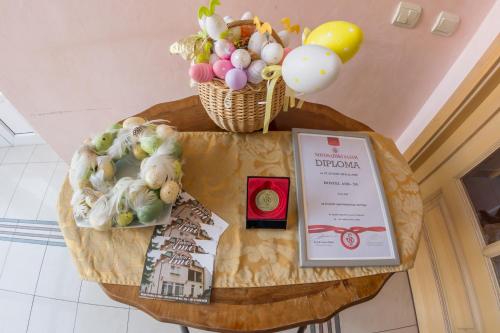 a table with a certificate and vegetables on it at Villa Ami in Novi Sad