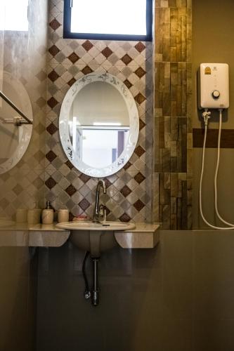 a bathroom with a sink and a mirror at The Boat House in Ranong