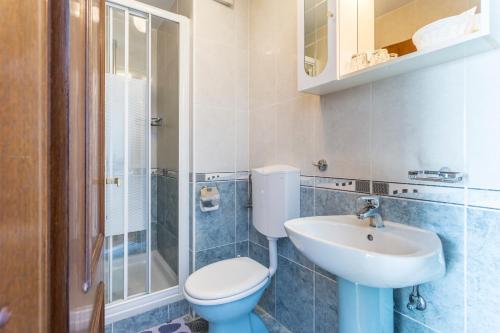 a bathroom with a toilet and a sink and a shower at Villa Amigo in Podstrana