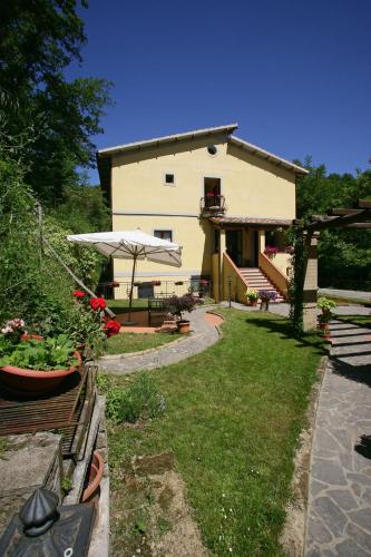 a building with a patio and a yard with flowers at Hotel Relais Valle Orientina in Pitigliano