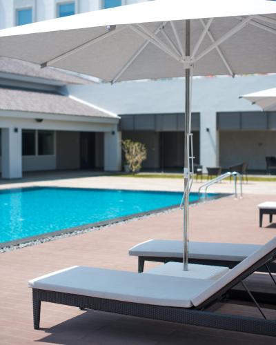 a table with an umbrella next to a swimming pool at The Residency Towers, Rameswaram in Rāmeswaram
