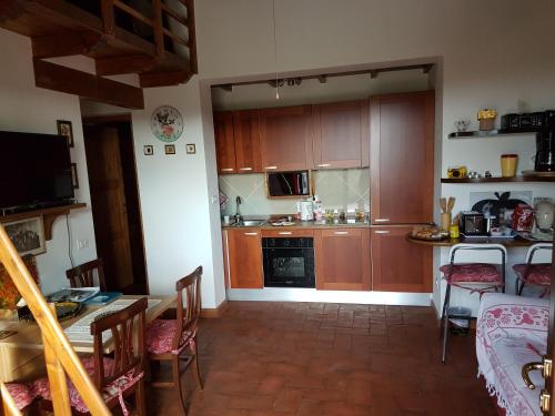 a kitchen with wooden cabinets and a table and chairs at Agriturismo Collelungo di Maremma in Diaccialone