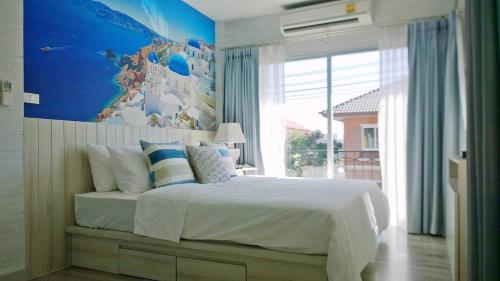 - une chambre avec un lit et une carte murale dans l'établissement Tascany Sea Beach Chaam-Huahin, à Cha Am