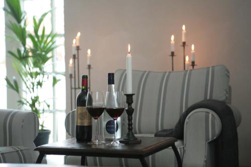 a table with wine bottles and wine glasses on it at Skanörs Gästgifvaregård in Skanör med Falsterbo