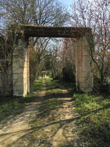 an old bridge over a dirt road with an archway at Les Terrasses De Chaumont 1 in Montsoreau