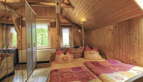 ein Schlafzimmer mit einem großen Bett in einem Zimmer mit Holzwänden in der Unterkunft Gasthaus Koenigsruhe in Thale