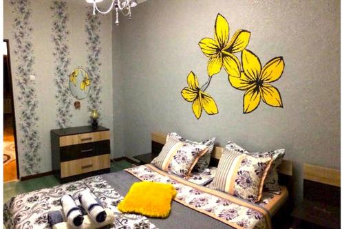 a bedroom with a bed with yellow butterflies on the wall at Apartments on Samal 1 in Almaty