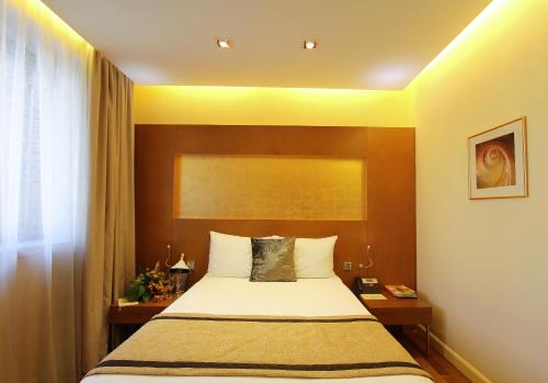 a bedroom with a bed and a window at The Dostyk Hotel in Almaty