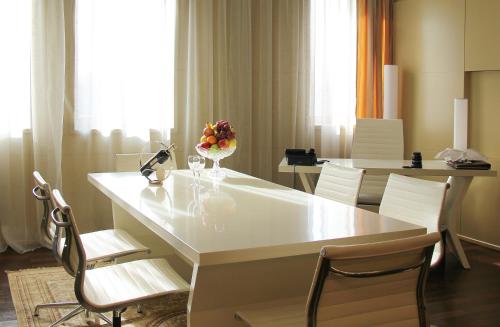 a dining room with a white table and chairs at The Dostyk Hotel in Almaty