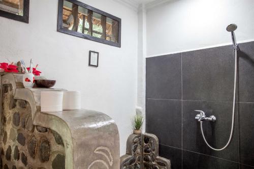 a bathroom with a shower stall and a toilet at EcoTravel Cottages Bukit Lawang in Bukit Lawang
