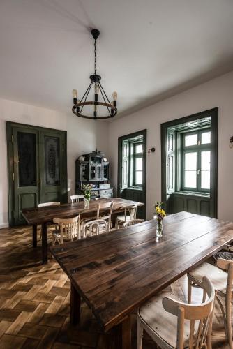 a dining room with a large wooden table and chairs at R40 Vendégház in Mád