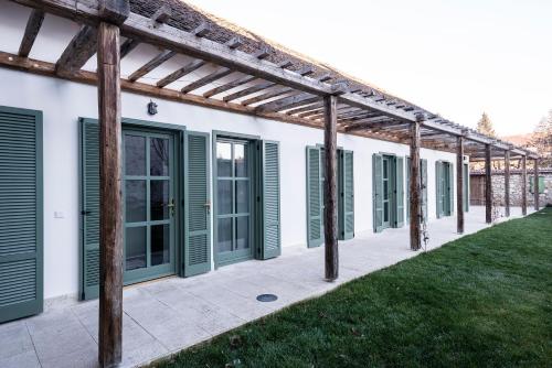 ein Haus mit grünen Rollläden und einer Terrasse in der Unterkunft R40 Vendégház in Mád